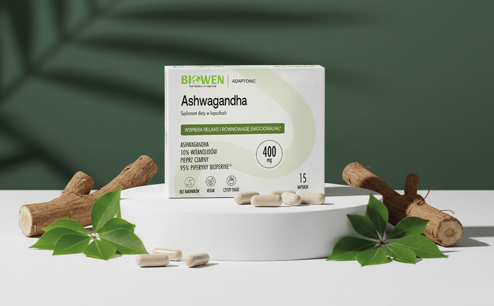 Ashwagandha Biowen Adaptonic z kapsułkami i naturalnymi elementami roślinnymi na zielonym tle￼