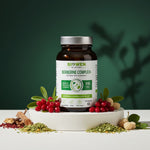 Opakowanie Berberyna Complex+ Biowen 60 kapsułek wśród liści, owoców i suszonych składników.