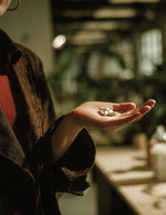 Kobieta trzyma na wyciągniętej dłoni kilka kapsułek CortiDay Biowen w wnętrzu z rozmytym tłem