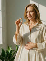 Kobieta w jasnej koszuli trzyma kapsułkę suplementu Hepa Strong Complex+ Biowen.