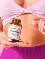 Kobieta trzymająca przy brzuchu opakowanie Biowen Maślan Sodu Forte Max 580 mg oraz kapsułkę dojelitową.