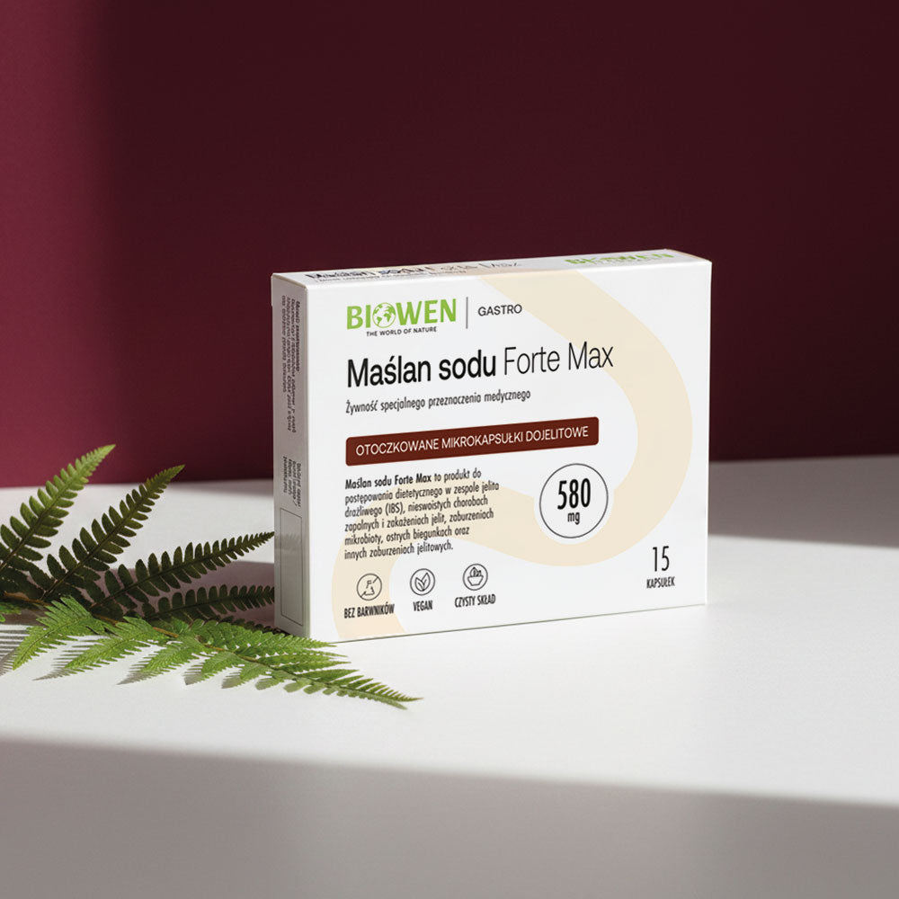 Opakowanie Maślan sodu Forte Max Biowen 580 mg na jasnej powierzchni z zielonym liściem paproci na tle bordowego tła