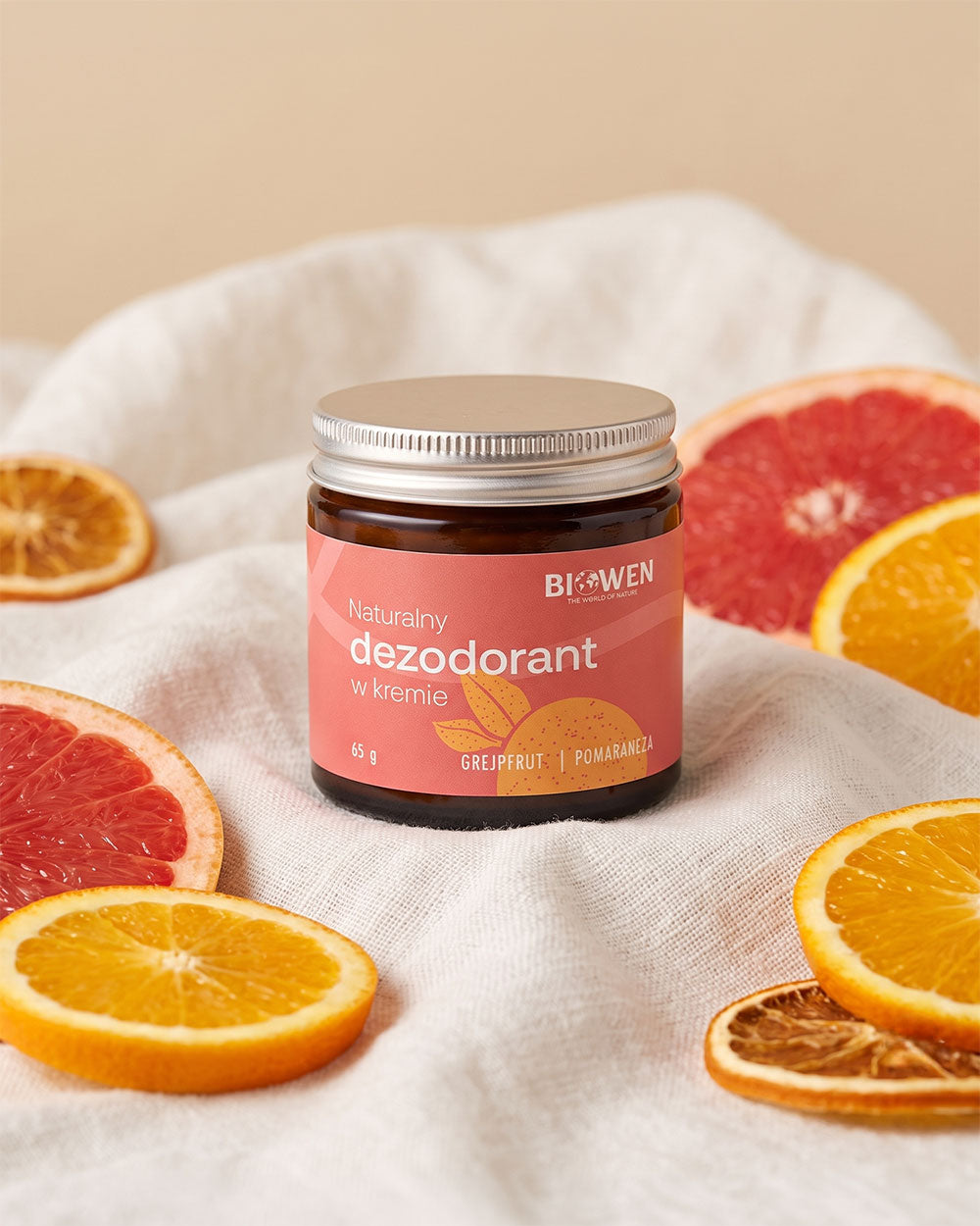 Naturalny dezodorant w kremie Biowen 65 g o zapachu grejpfruta i pomarańczy, otoczony plasterkami cytrusów.