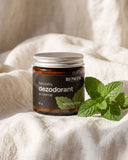 Naturalny dezodorant w kremie Biowen 65 g o zapachu mięty pieprzowej, przedstawiony obok świeżych liści mięty.
