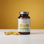 Butelka suplementu Omega 3 Biowen 90 kapsułek z żółtymi kapsułkami na białym blacie i żółtym tle.