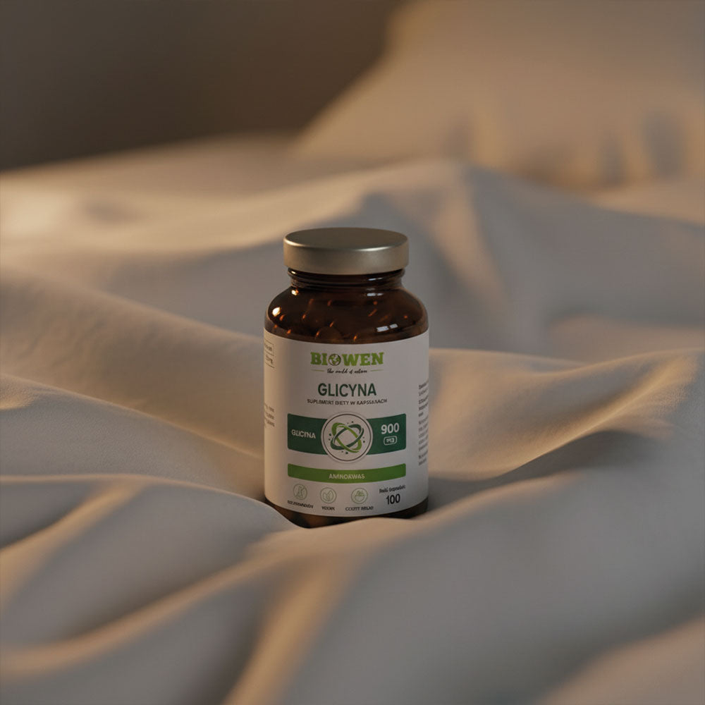 Słoik suplementu Glicyna Biowen 100 kapsułek ustawiony na zmiętej, jasnej pościeli w ciepłym świetle.