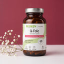 Q-Folic Biowen 600 µg, suplement diety z aktywnym folianem 5-MTHF Quatrefolic, opakowanie 90 kapsułek na różowym tle z białymi kwiatami.