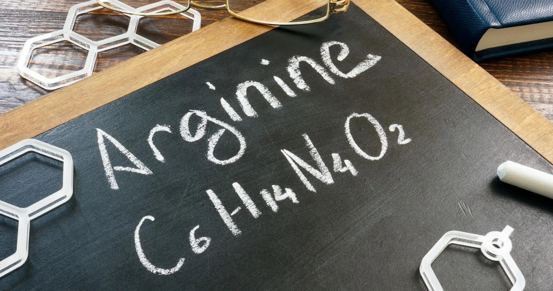 Wzór chemiczny argininy zapisany kredą na tablicy – symboliczna prezentacja budowy aminokwasu.
