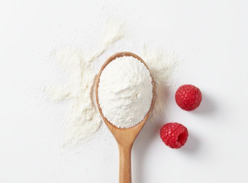 Drewniana łyżka z proszkiem Elektrolity Vital Charge+ Biowen malinowe i dwiema malinami obok.