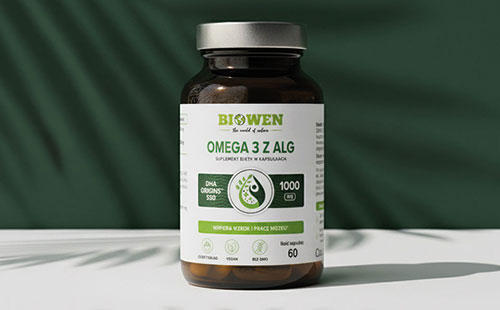 Słoiczek suplementu Omega 3 z alg Biowen 60 kapsułek na tle zielonej tkaniny z cieniem liści.