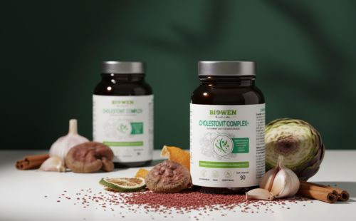 Dwa słoiczki suplementu Biowen Cholestovit Complex+ na tle zieleni w otoczeniu naturalnych składników