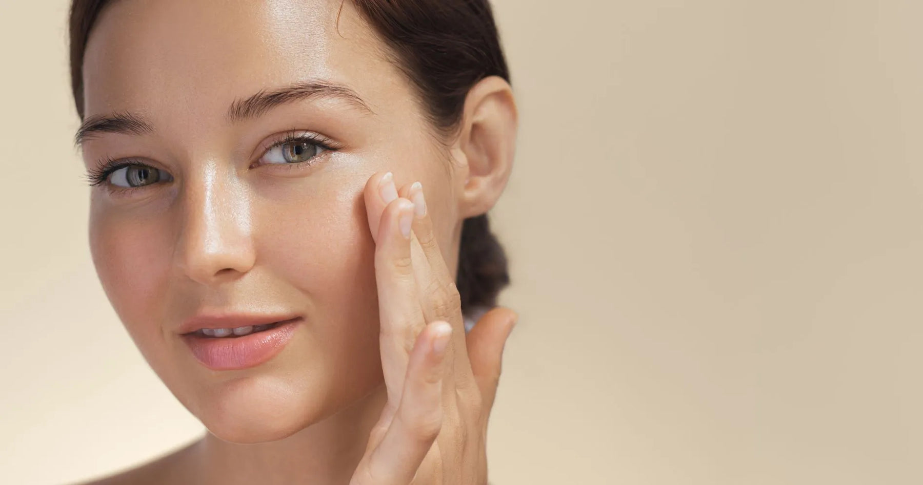 Kobieta nakładająca kosmetyk na twarz – pielęgnacja skóry z użyciem kwasów AHA.