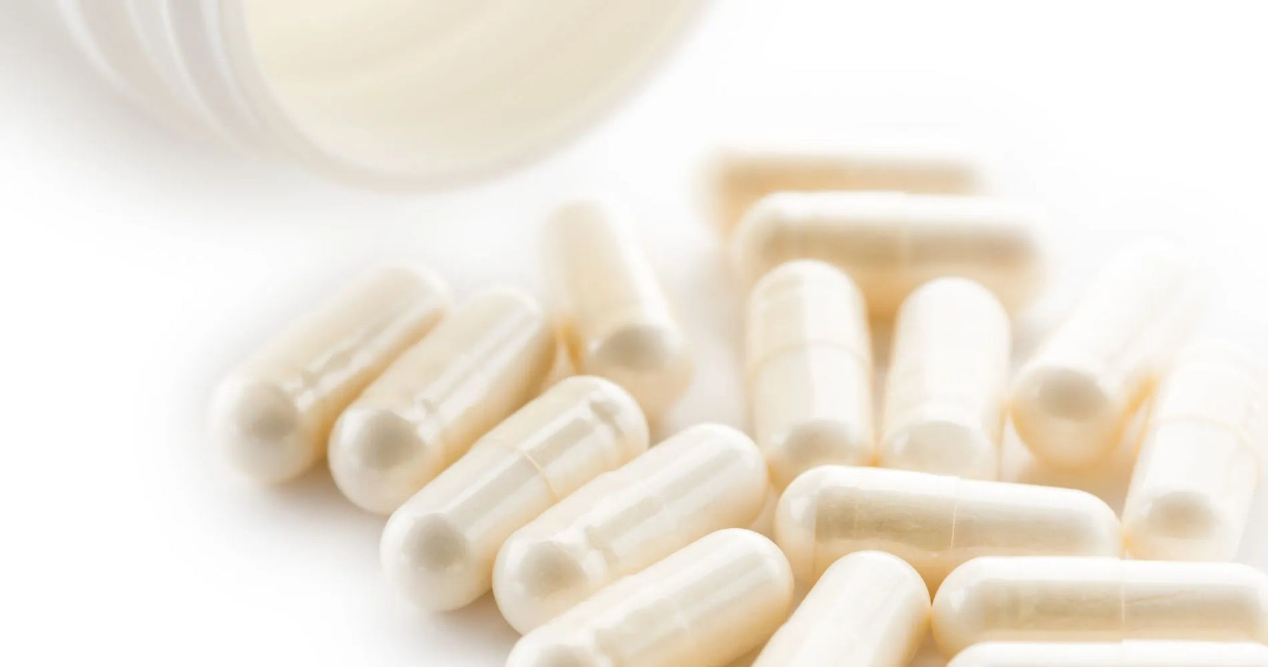 Białe kapsułki laktoferyny jako suplement diety wspierający odporność i gospodarkę żelazem.
