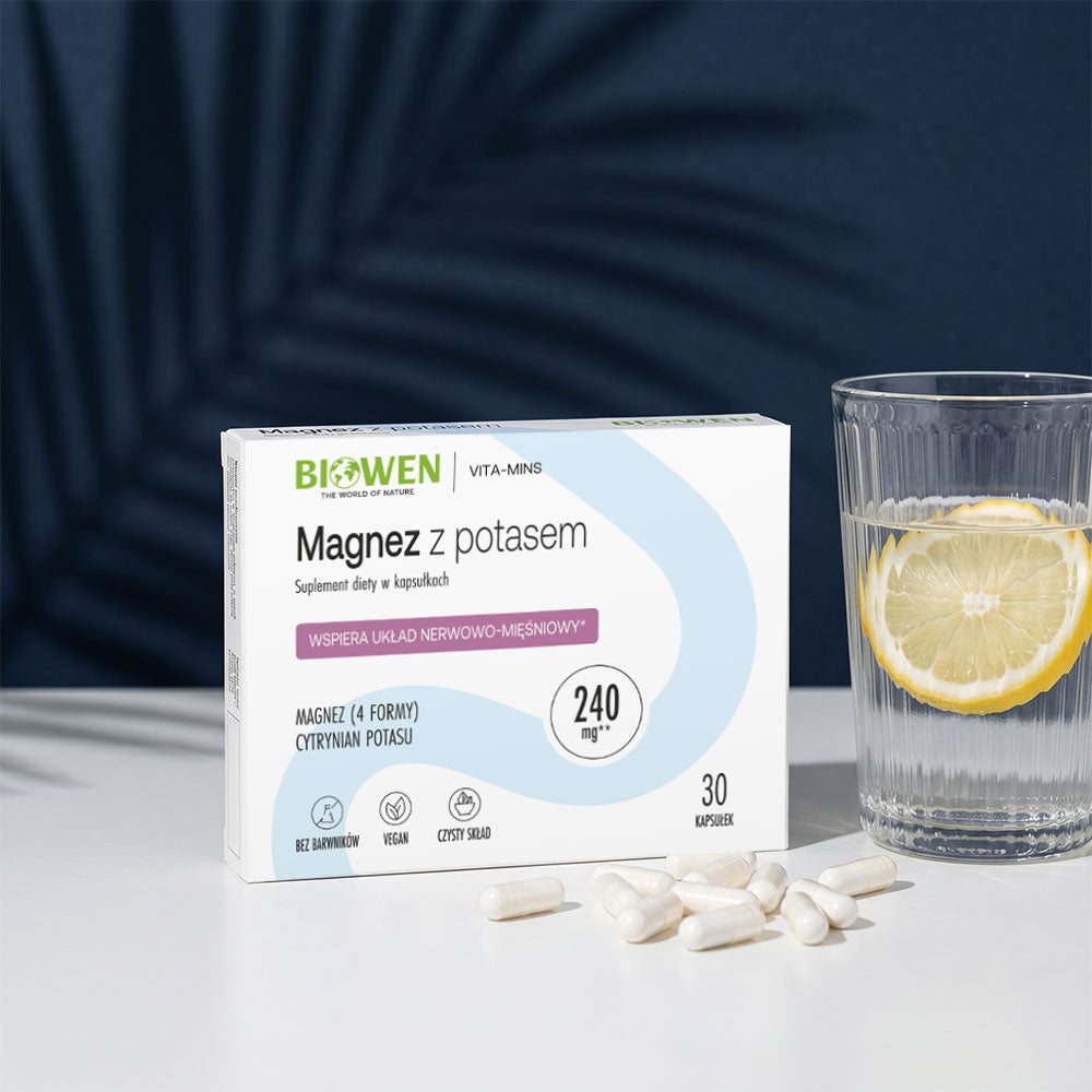 Magnez z potasem Biowen – suplement diety w kapsułkach obok szklanki wody z cytryną na ciemnoniebieskim tle