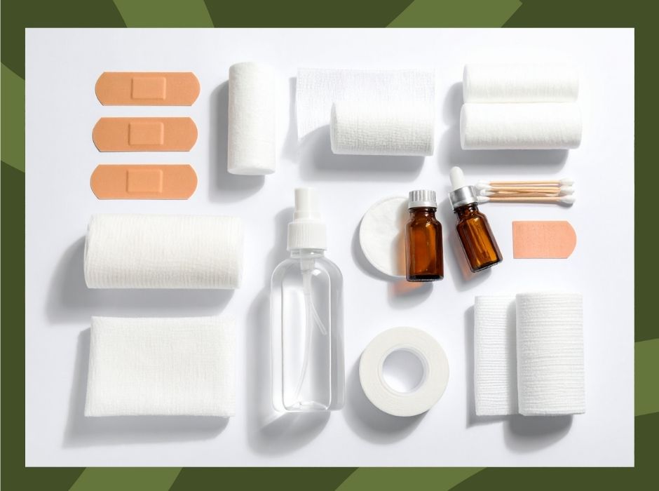 Zestaw materiałów opatrunkowych i akcesoriów do pielęgnacji ran ułożonych na białym tle.