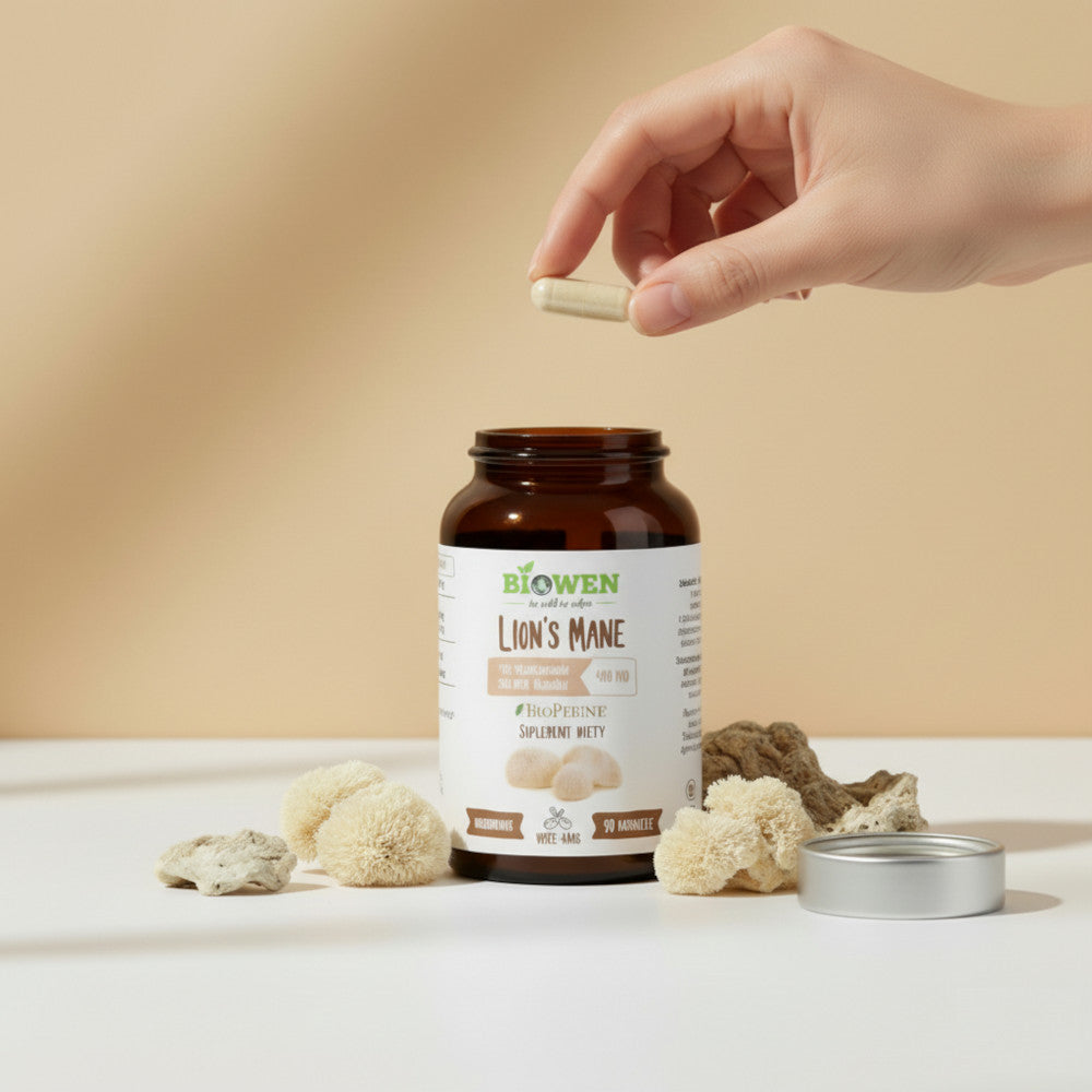 Otwarte opakowanie suplementu Biowen Lion’s Mane 90 kapsułek z jedną kapsułką w dłoni