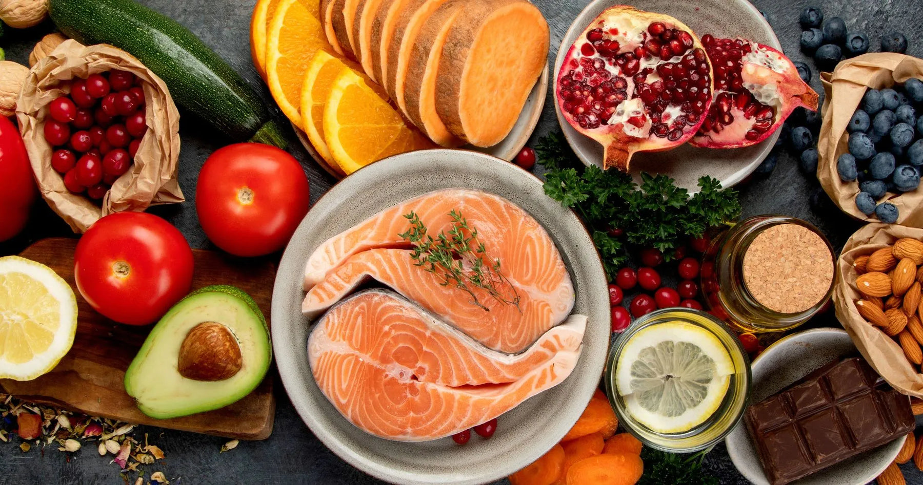 Produkty wspierające dietę anti-aging: łosoś, awokado, orzechy, warzywa, owoce i gorzka czekolada.