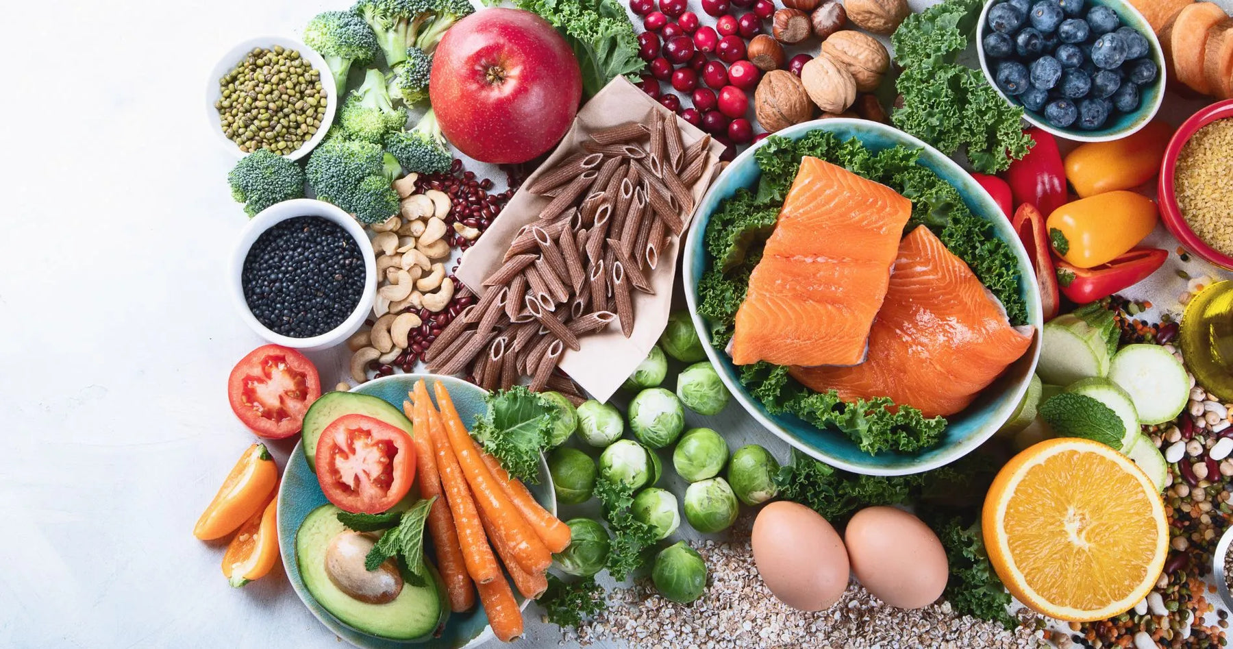 Zdrowe produkty wspierające regenerację po kontuzji – warzywa, owoce, łosoś, jajka, orzechy i pełnoziarnisty makaron.