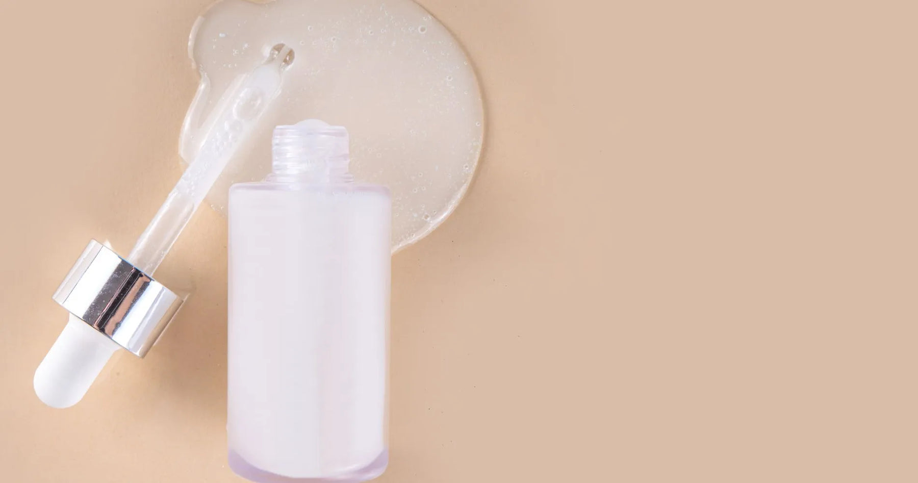 Serum z ceramidami w szklanej butelce z pipetą na beżowym tle.