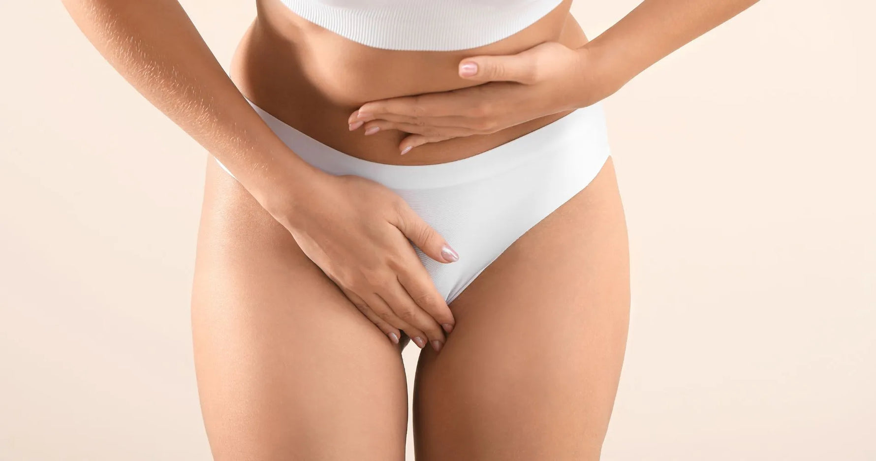 Kobieta trzymająca dłonie na podbrzuszu – objawy zespołu policystycznych jajników (PCOS).